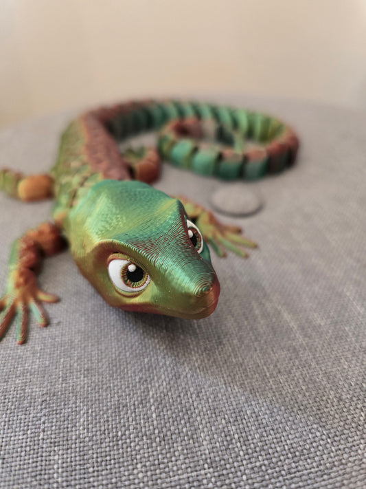 Gros plan sur la tête du lézard Abronia articulé, mettant en valeur ses grands yeux expressifs et la texture détaillée des écailles en PLA.