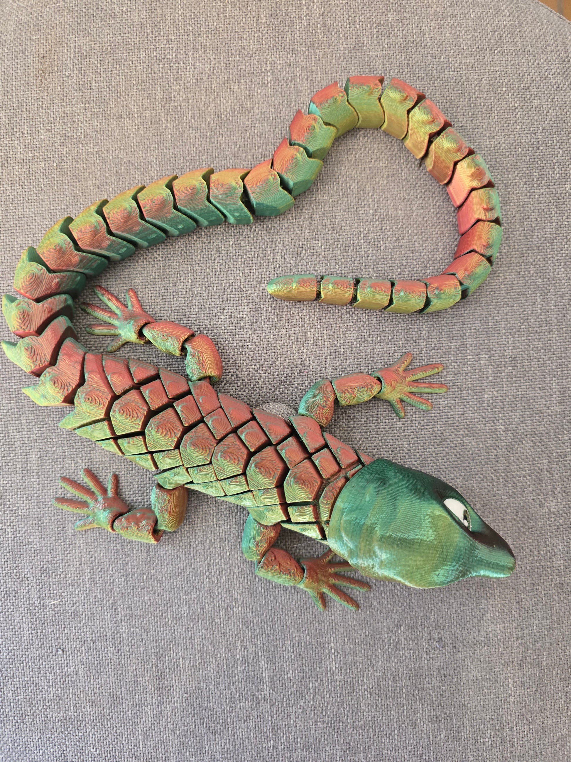 Détail sur le corps segmenté et la queue flexible du dragon Abronia, démontrant ses nombreuses articulations fluides idéales pour la détente (effet fidget).